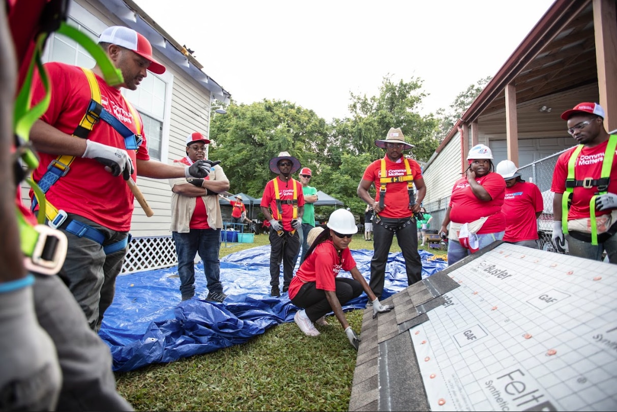 A group of GAF Roofing Academy students and Anthony Mackie learning, hands-on, how to properly install a roof