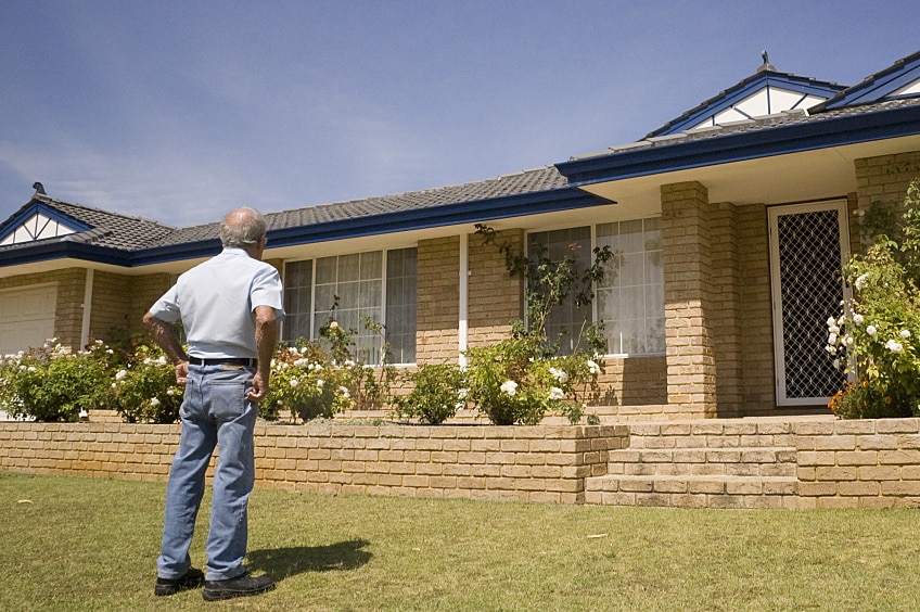 Man inspecting his roof from the ground