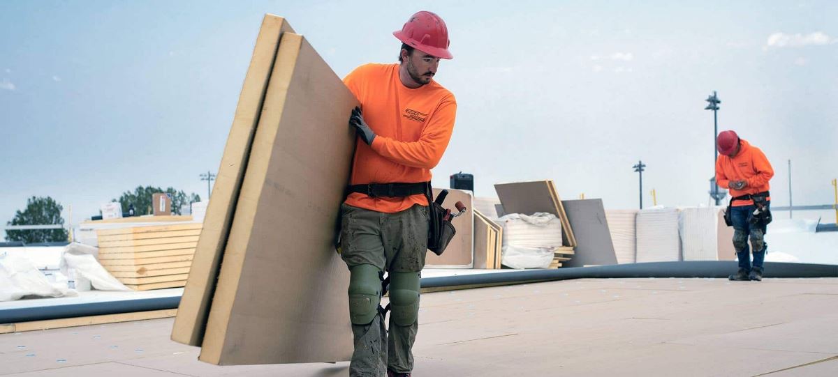 Contractor holding GAF EnergyGuard Polyiso Insulation on the Bozeman Public Safety Center roof