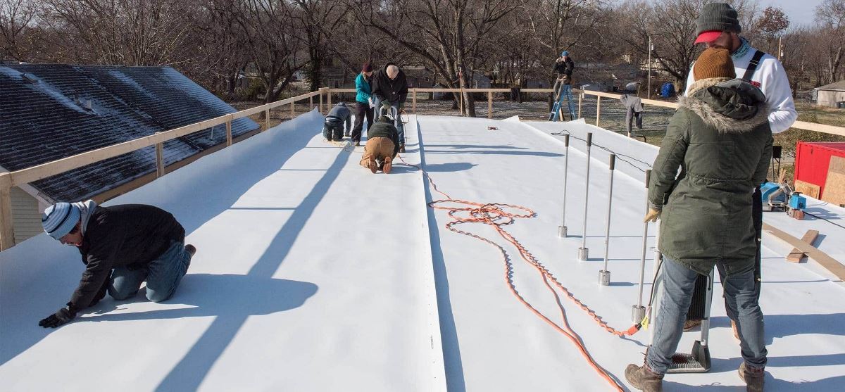 Students on roof installing GAF EverGuard 60 mil TPO and the RhinoBond attachment System