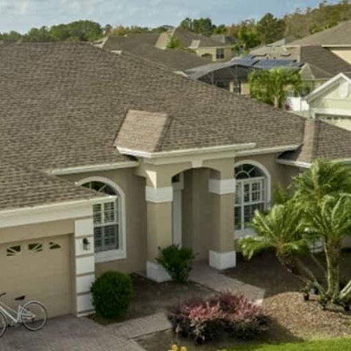 Brown GAF Timberline HDZ shingles on a beige stucco home.