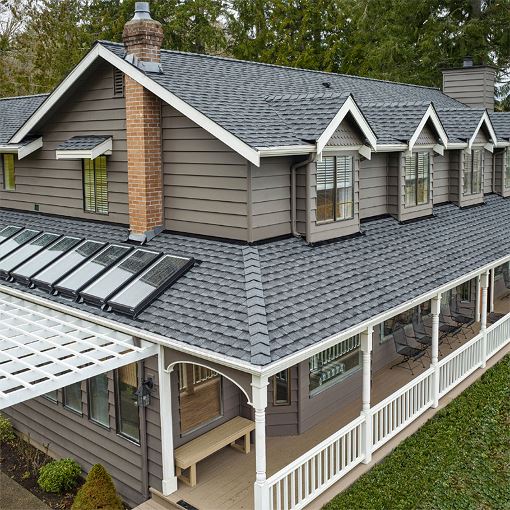 Beige home with a gray roof featuring new GAF Timberline UHDZ shingles.