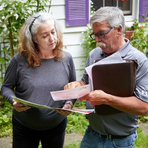 Two people discussing options with documents in hand