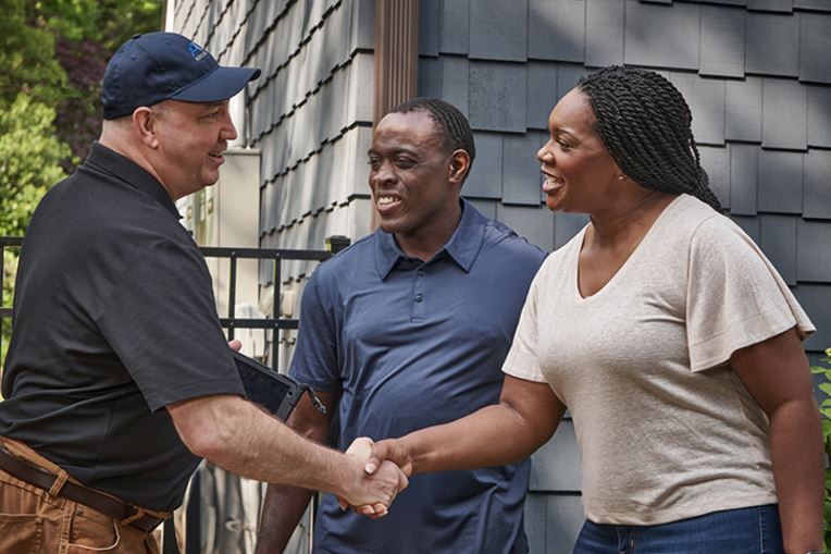 Homeowners shaking hands with a GAF certified roofer