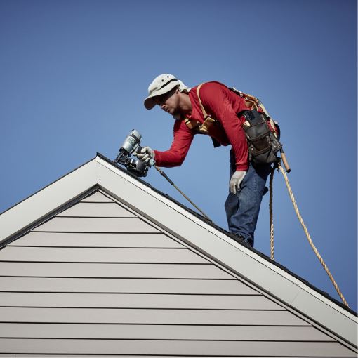 Contractor installing GAF shingles on a roof.