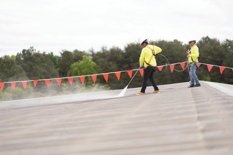 Contractors preparing roof for coatings