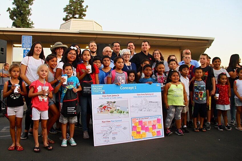 A group of Shafter community members stand before a poster with an expansion concept and feedback.