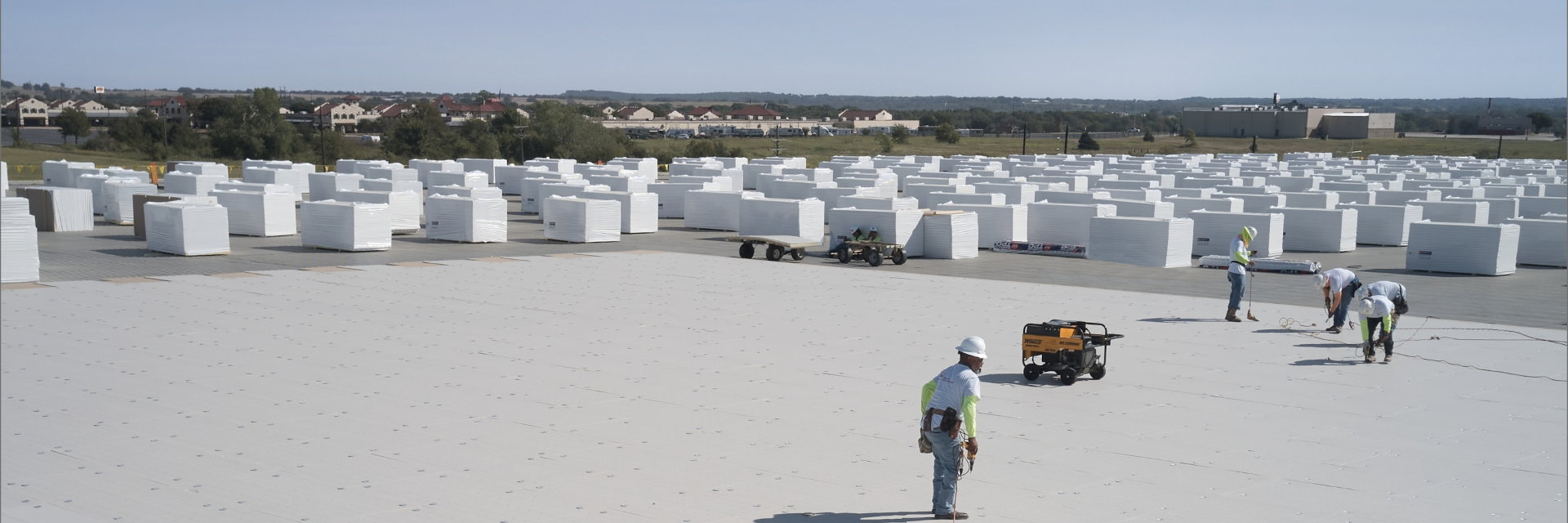 GAF commercial roofing certified contractors using time-saving products on a flat white roof