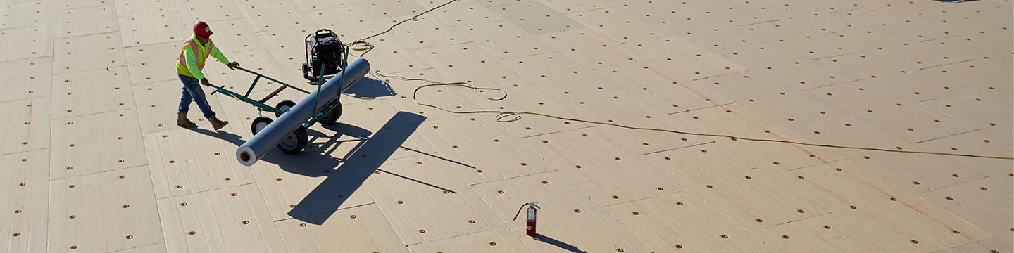 Applying roof insulation to low-slope roof