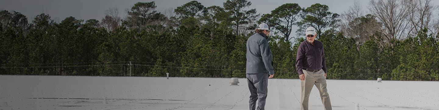 Contractor looking at flat roof with property manager