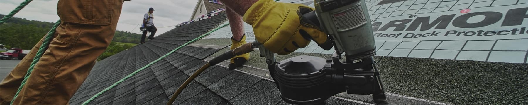 Contractor nailing GAF shingles on a home, one of the six parts of a roof system