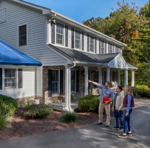 Homeowners outside house with roofing contractor