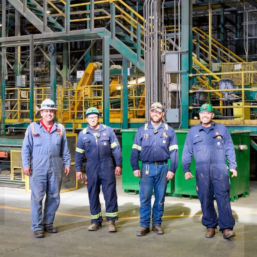 Four GAF employees working at roofing manufacturing plant