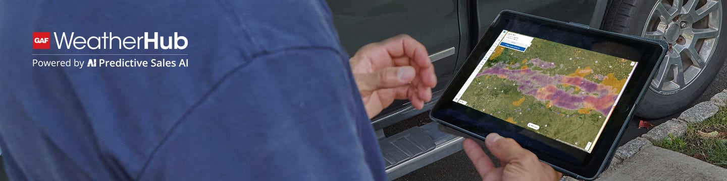 Person holding tablet open to hail map and weather data from GAF roofing