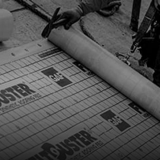 Shaded image of a GAF roofer installing a GAF roof deck protection underlayment sheet