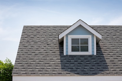 Asphalt roof shingles with sun beaming on the roof