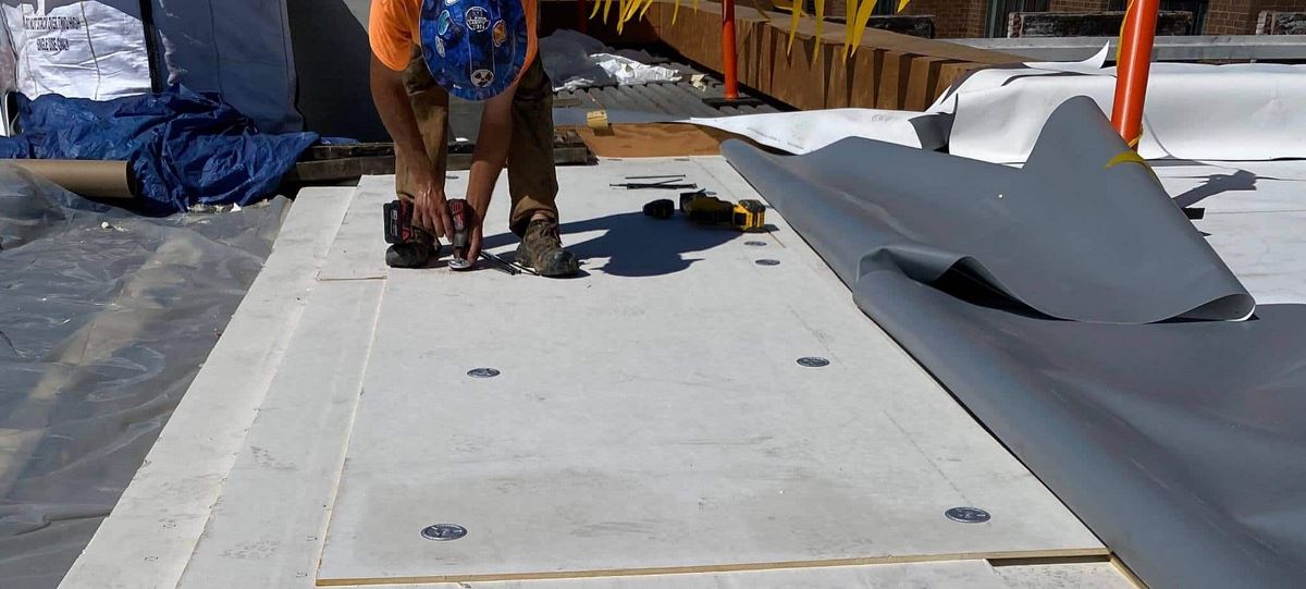 Construction workers installing a new commercial roof with GAF products on the Stanley Center.