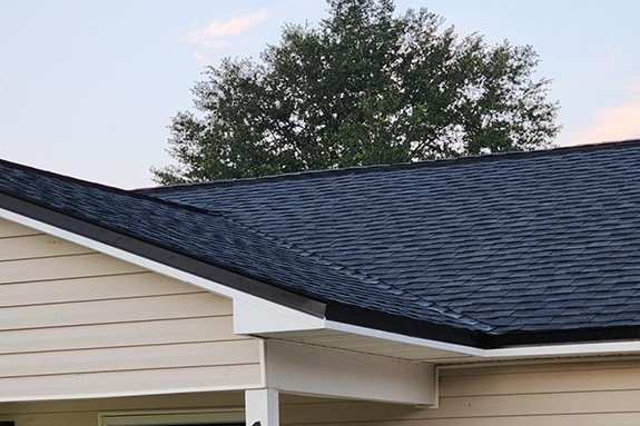 Close up of beige home with black GAF shingles