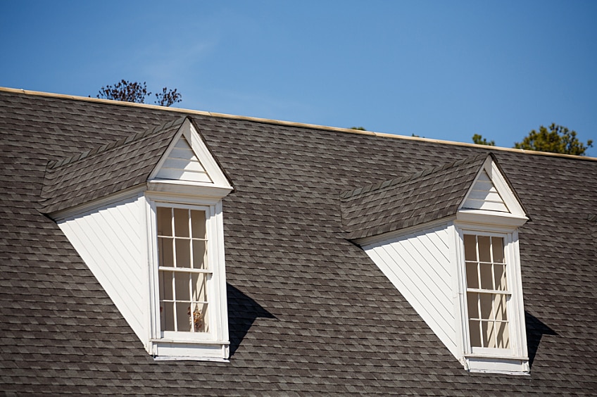 A large dormer with roofing tiles and an angled window.