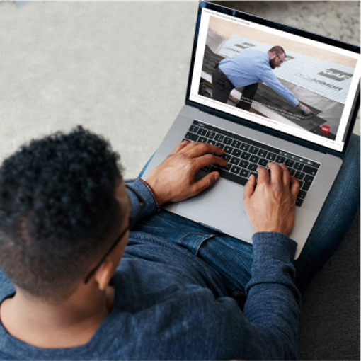 Contractor watching GAF roofing video on laptop