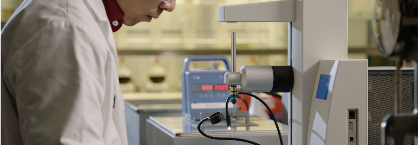 GAF scientist in a lab with machinery to advance our roofing products.