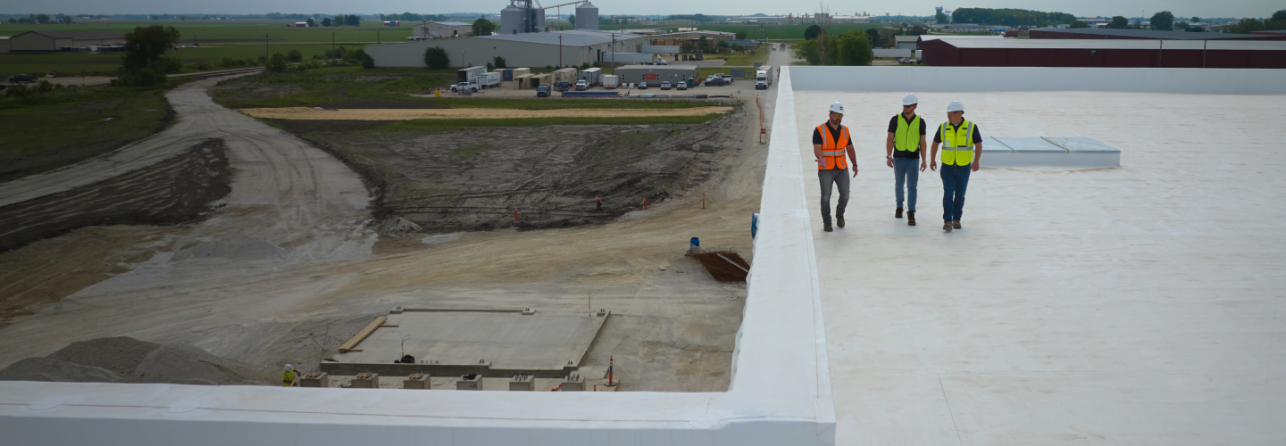 GAF certified roofing contractors walking on a commercial flat roof