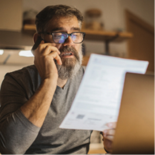 Man on phone holding up papers